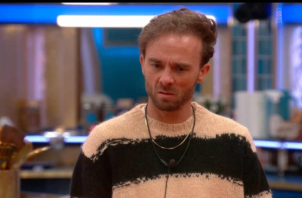 Screenshot of a man wearing a striped sweater, looking concerned.