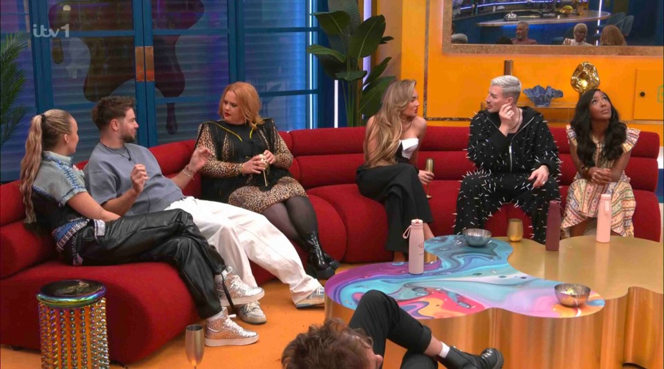 Celebrity Big Brother contestants sitting on a red sofa.