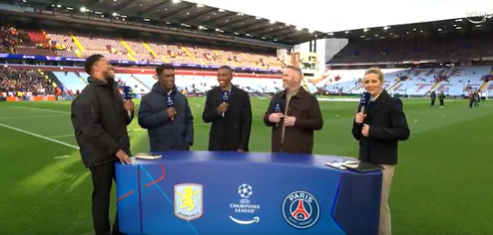 Five sportscasters stand behind a desk at a soccer stadium, broadcasting a Champions League match between Aston Villa and Paris Saint-Germain.