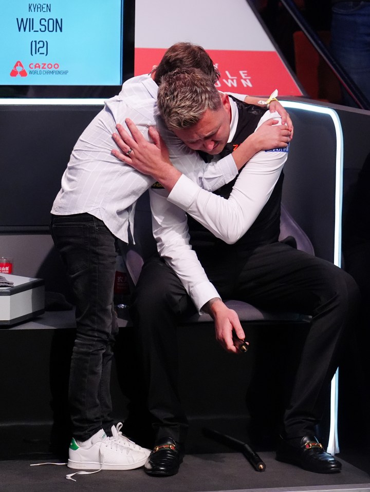 Kyren Wilson embraces his son after a snooker championship win.