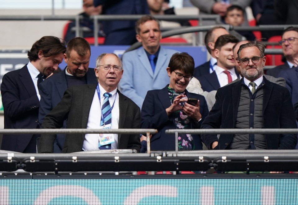 Group of people watching a sporting event at Wembley Stadium.