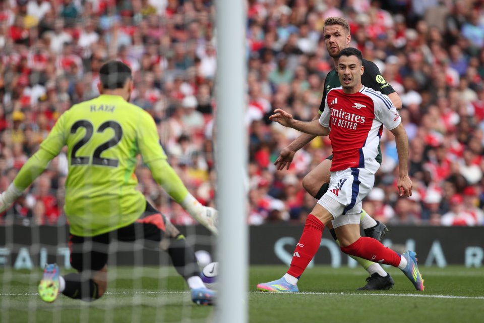 Arsenal player avoids Brentford player's shot.