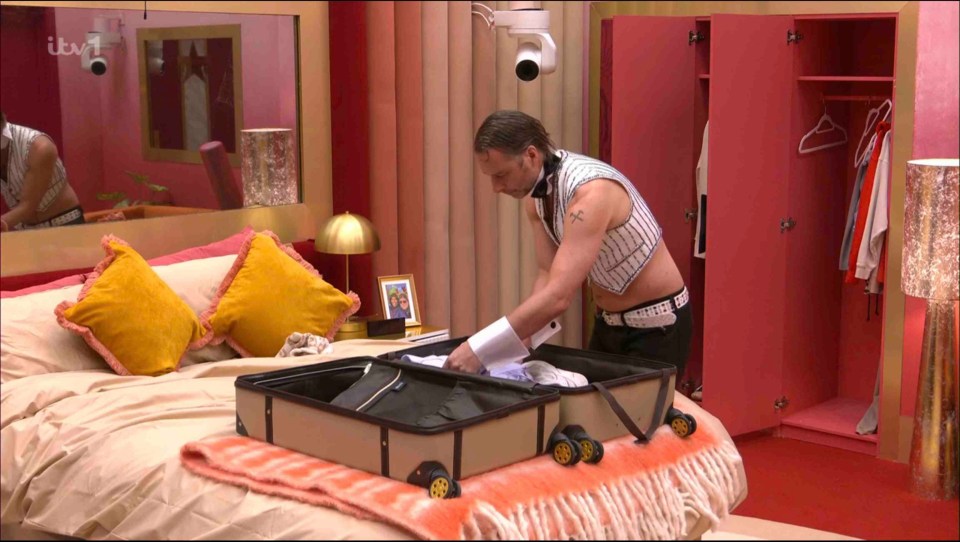 A man packing a suitcase in a brightly colored bedroom.