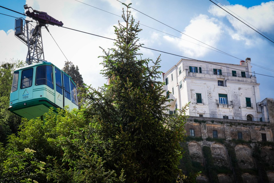Cable car ascending to a building on a hillside.