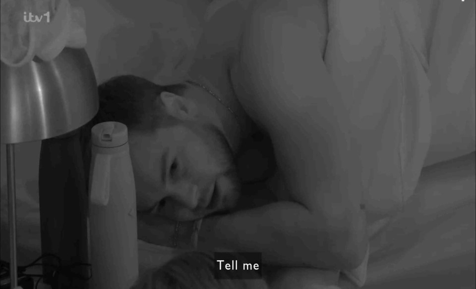 Black and white image of a man lying in bed.