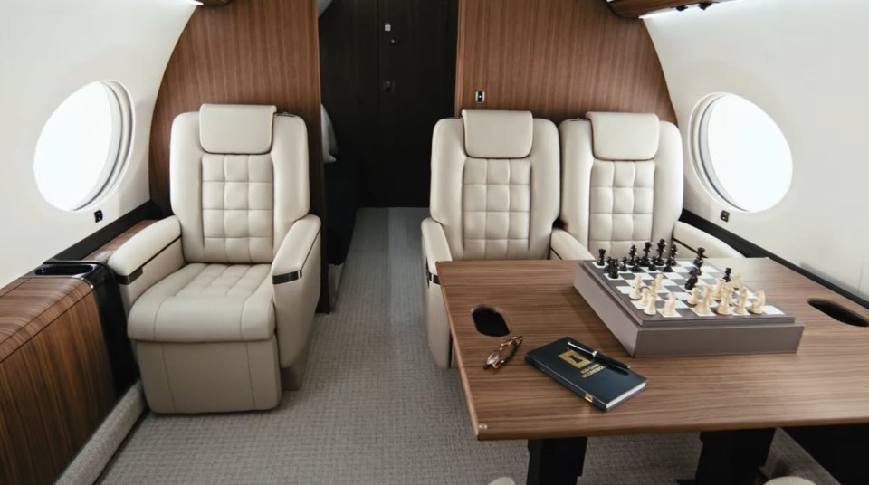 Interior of Elon Musk's private jet showing two seats and a chessboard.