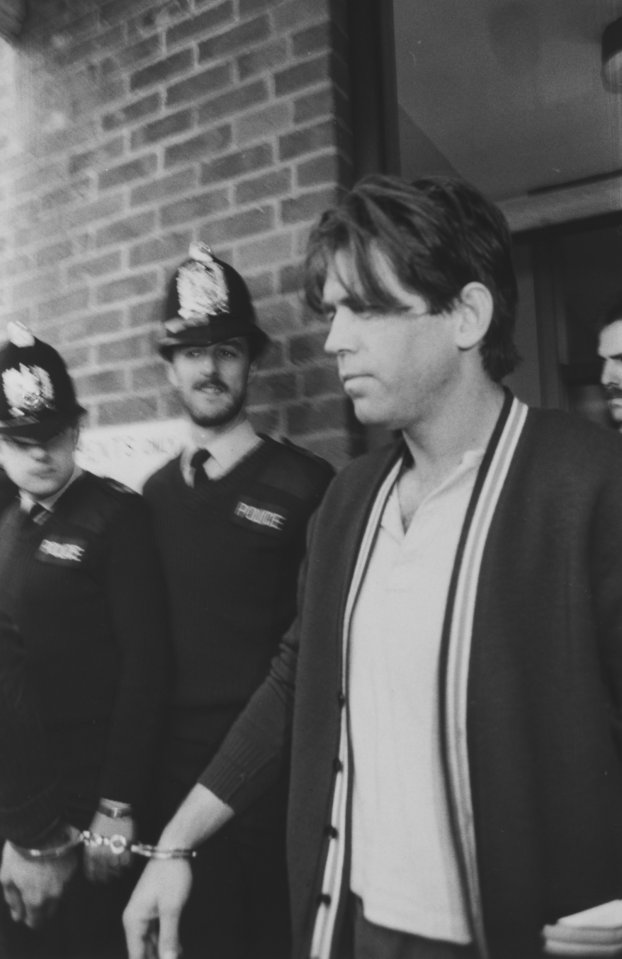 Black and white photo of George Stephenson, a suspect in the Fordingbridge massacre, in handcuffs with police officers.