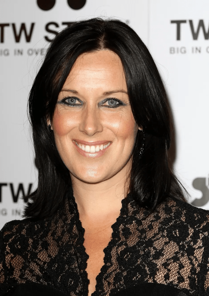 Headshot of a woman with dark hair wearing a black lace top.