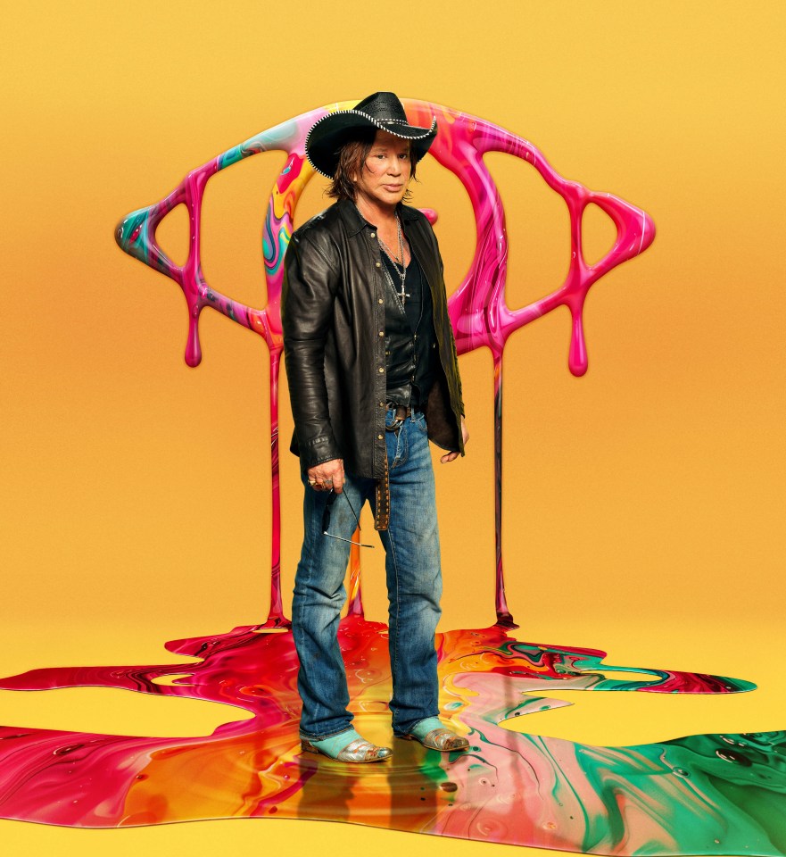 Mickey Rourke standing on colorful paint, wearing a cowboy hat and leather jacket.