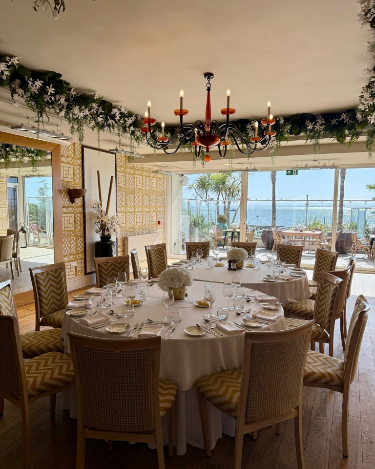 Ocean-view dining room table set for a meal.