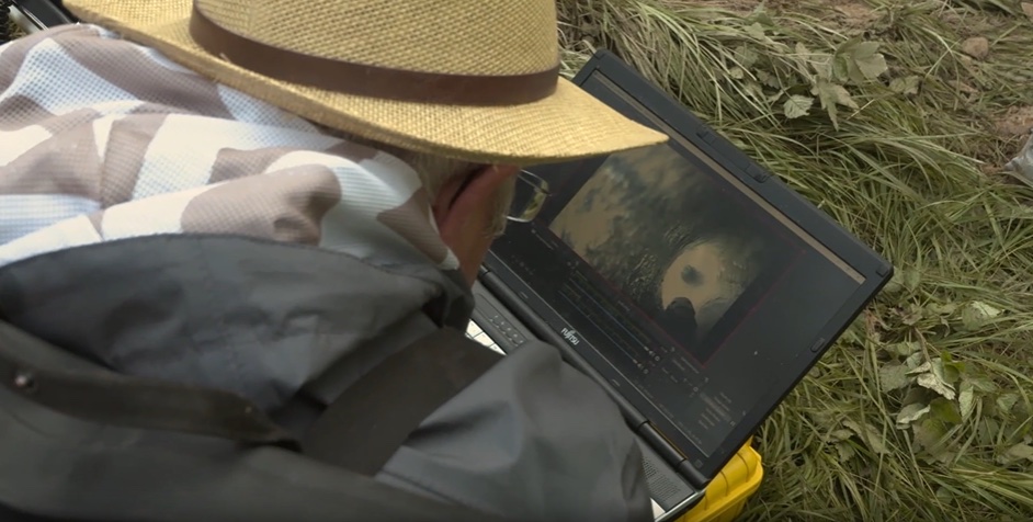 Person reviewing Nazi loot on a laptop outdoors.