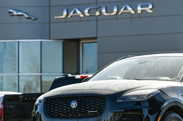 An image collage containing 1 images, Image 1 shows Black Jaguar parked in front of a Jaguar dealership