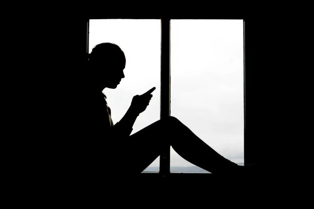 An image collage containing 1 images, Image 1 shows Silhouette of a girl texting by a window