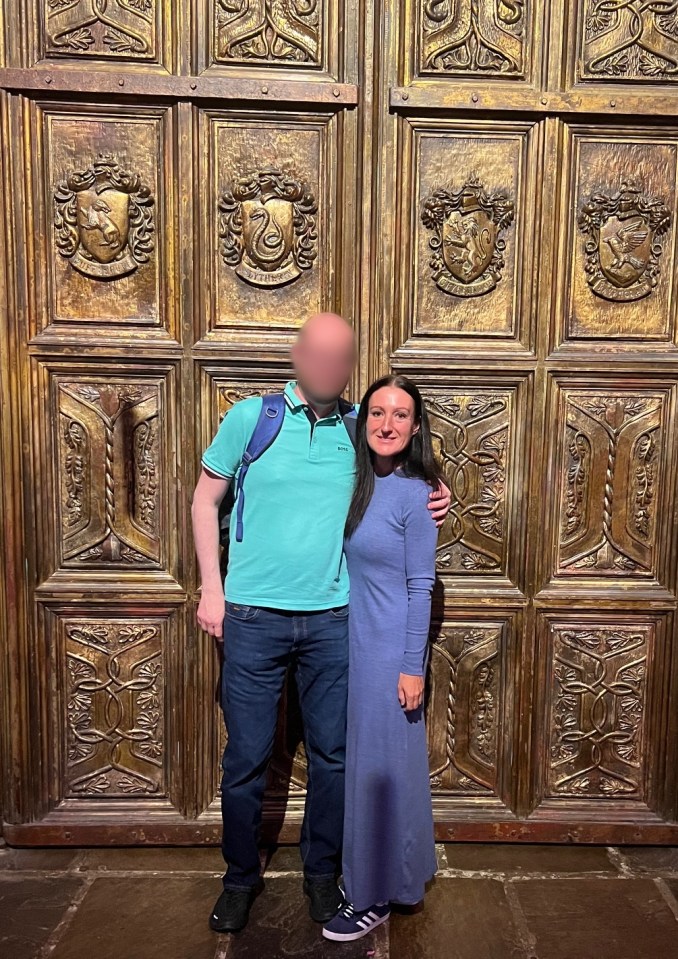 Couple posing in front of ornate doors.