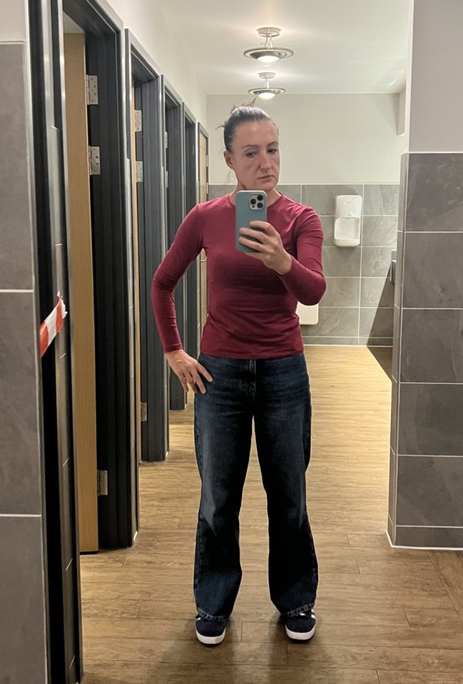 Woman taking a selfie in a gym restroom.