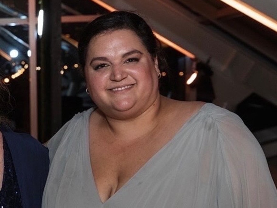 Headshot of Amy Kane, smiling, wearing a light gray dress.
