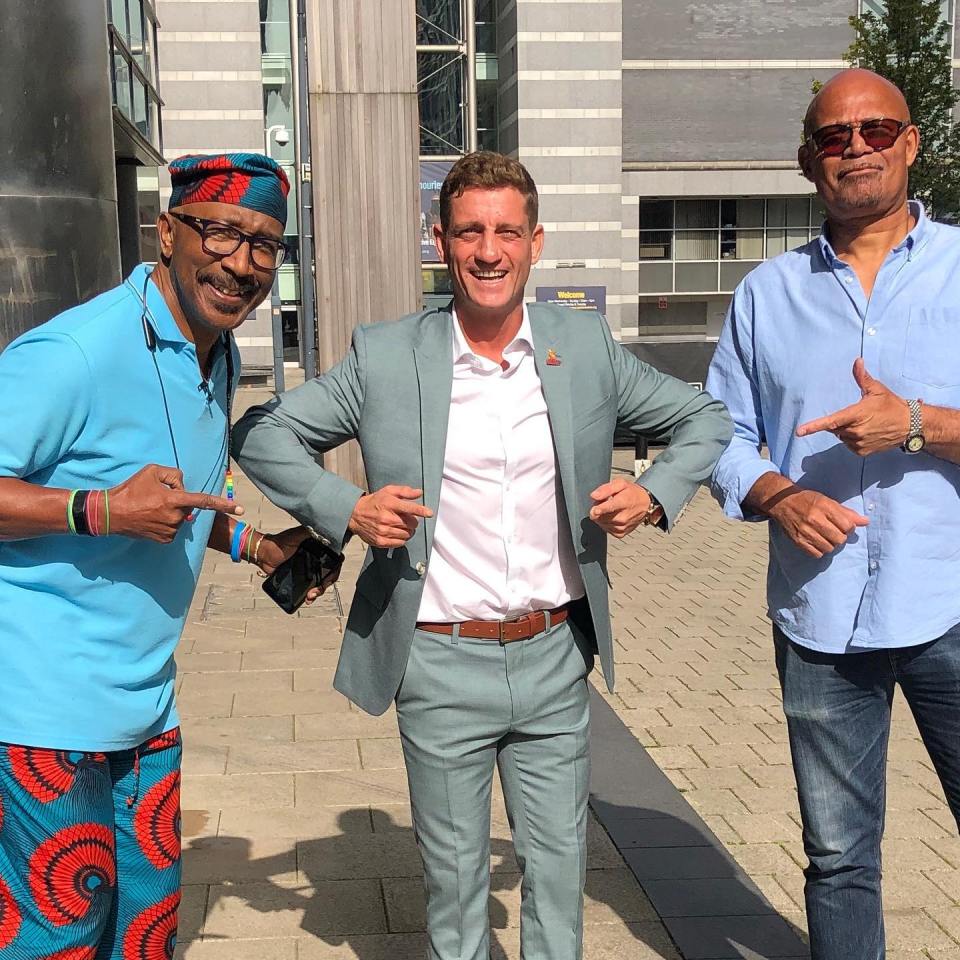 Three men posing outdoors.