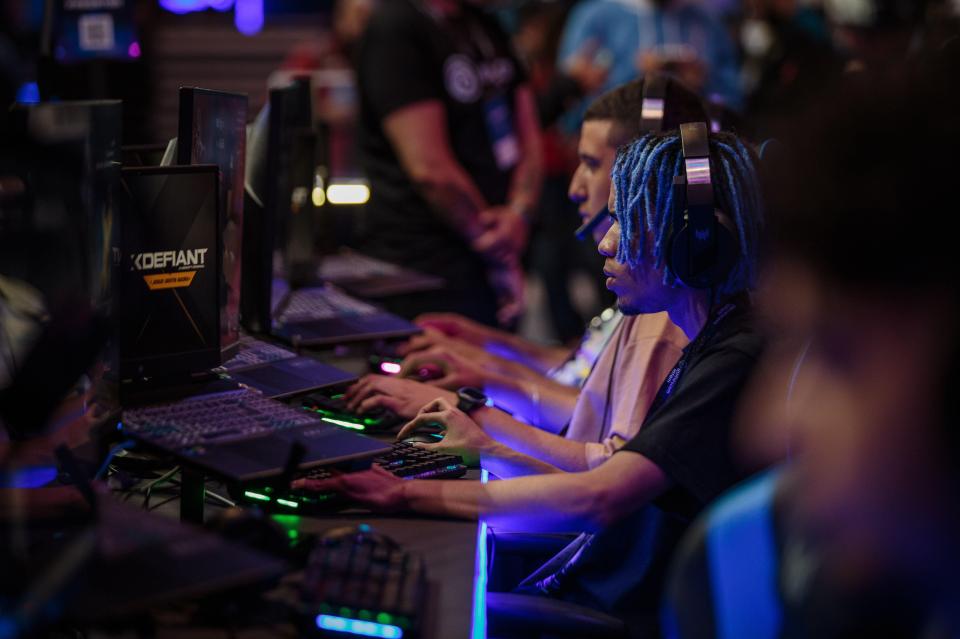 Young people playing XDefiant at a video game trade fair.