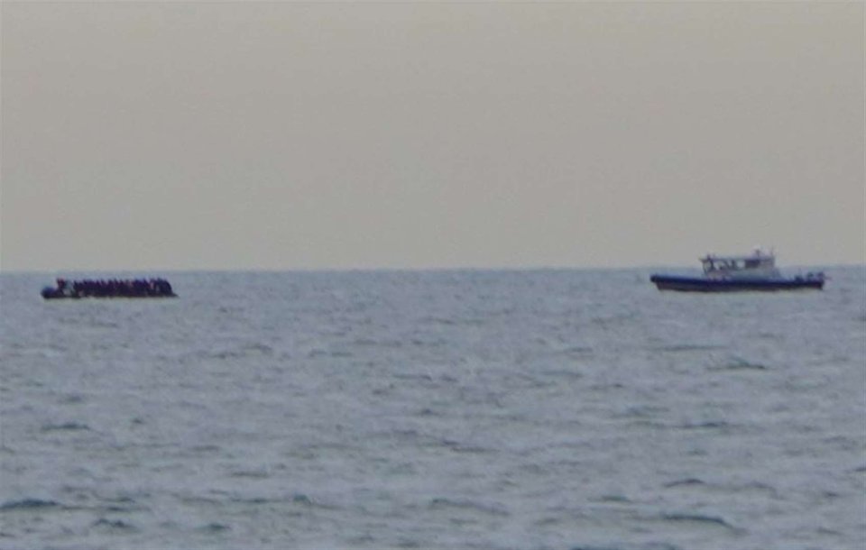 Migrant boat and patrol boat at sea.
