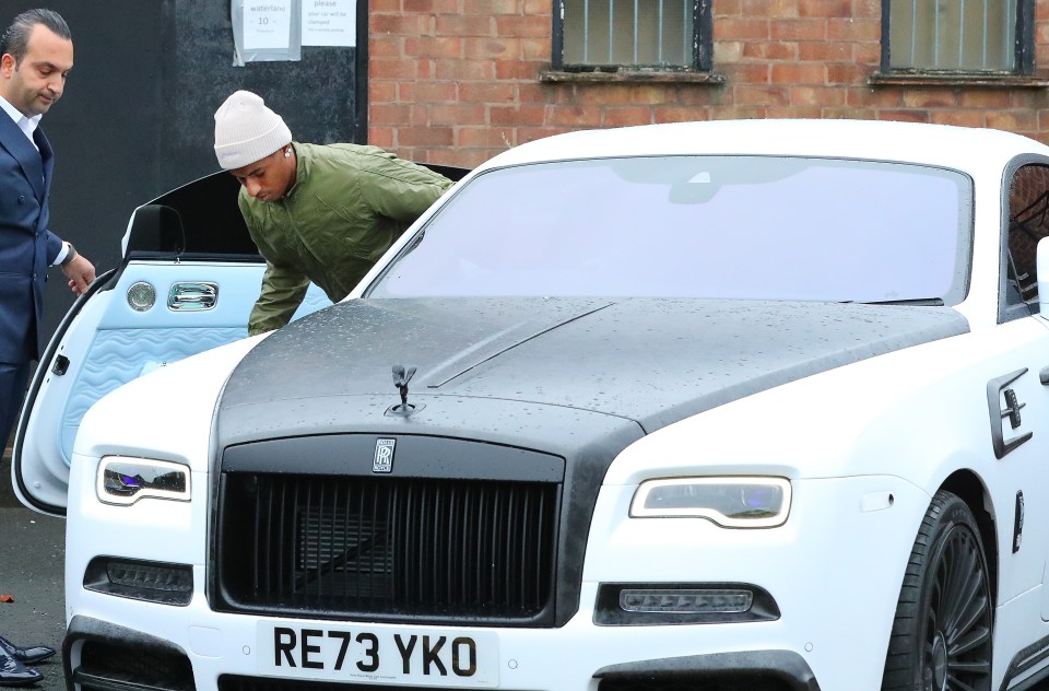 Marcus Rashford getting into his Rolls Royce Wraith.