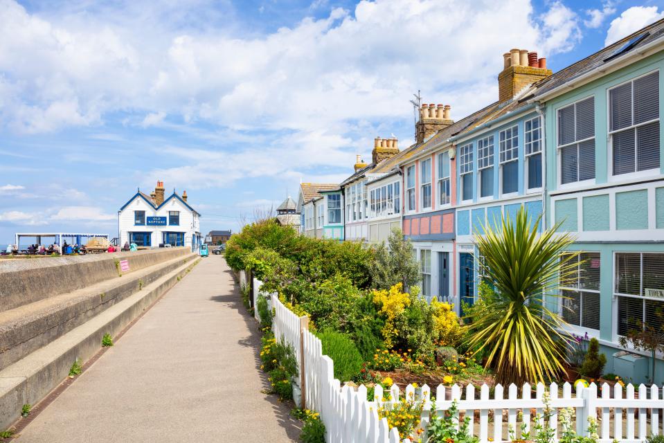 Row of colorful houses and a pub by the sea.