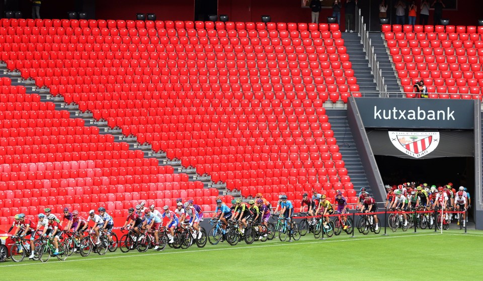 Cyclists at the start of a race in a stadium.