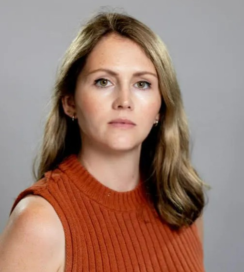 Headshot of a woman wearing a rust-colored ribbed tank top.