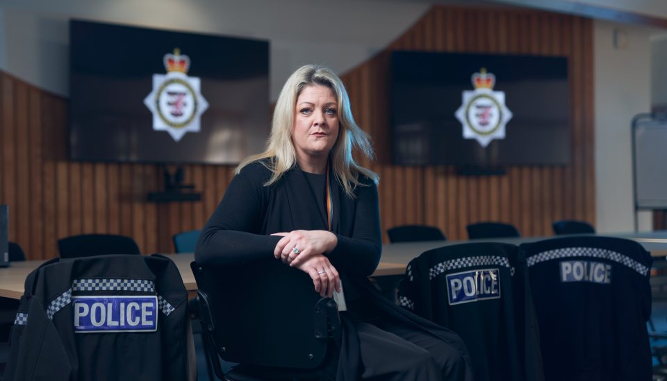 Amber, from the Channel 4 program To Catch a Copper, sits in a chair in a police conference room.