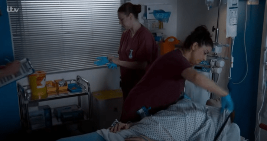 Screenshot of medical personnel attending to a patient in a hospital room.