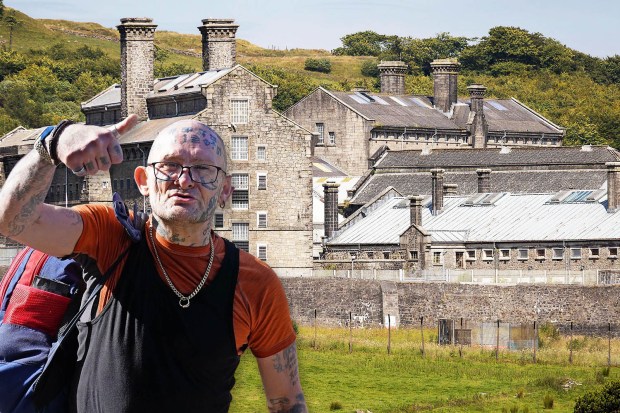 A tattooed man gives a thumbs-up in front of HMP Dartmoor.