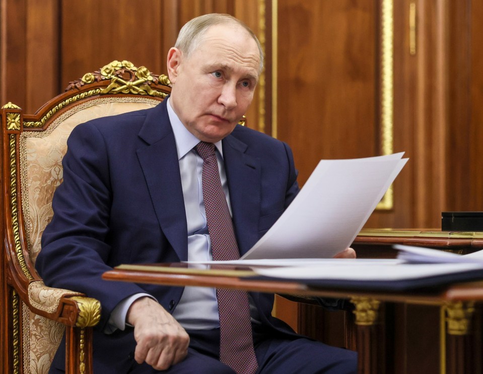 Vladimir Putin reviewing documents.