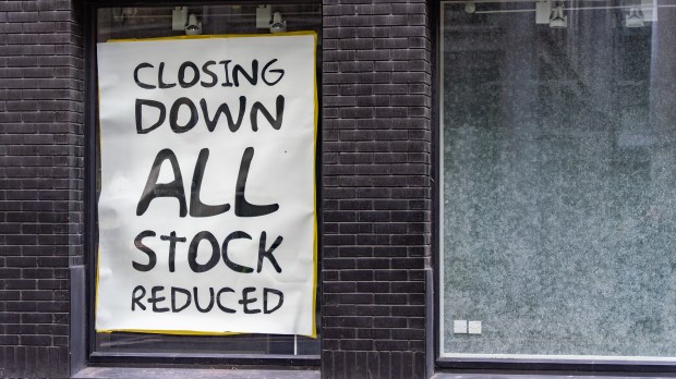 Store window with a sign that says "CLOSING DOWN ALL STOCK REDUCED".