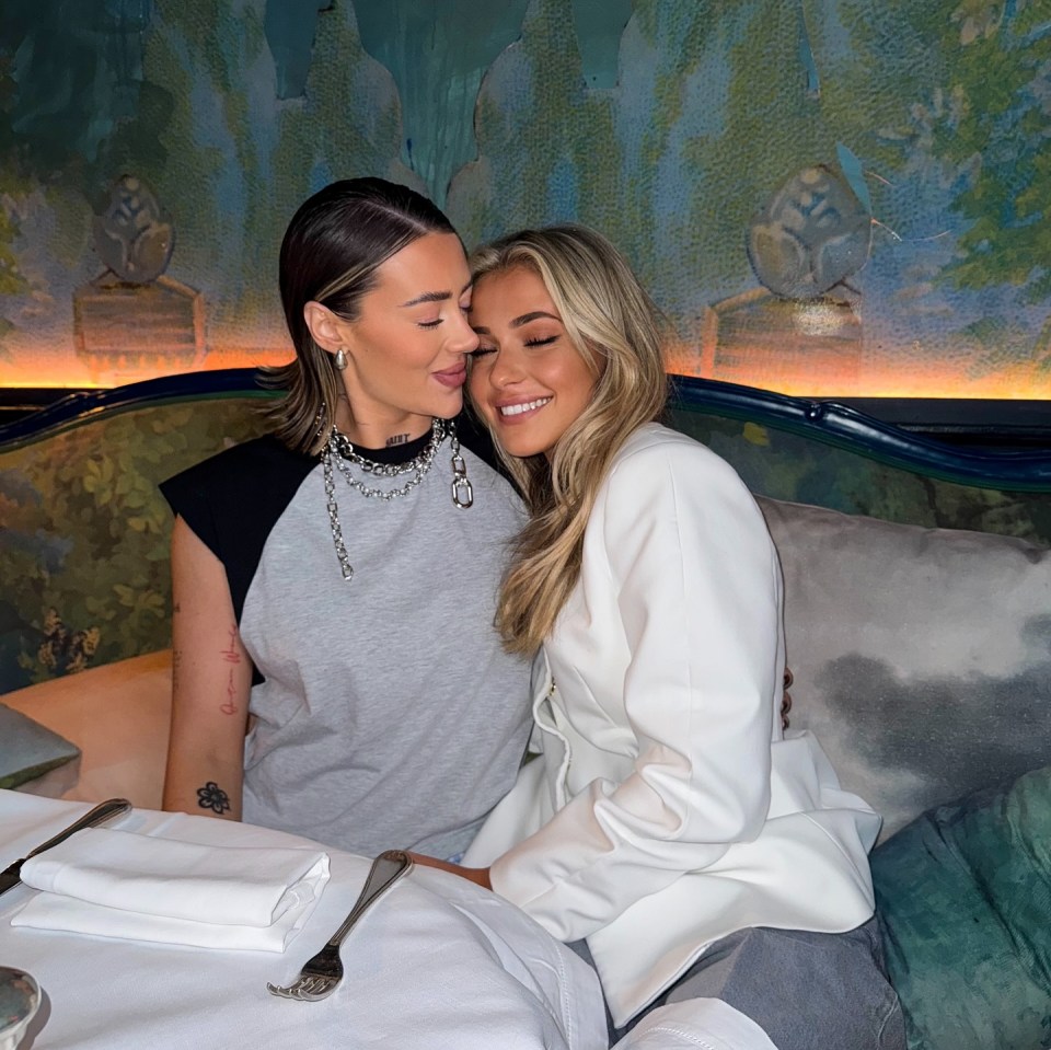 Two women embracing at a restaurant.
