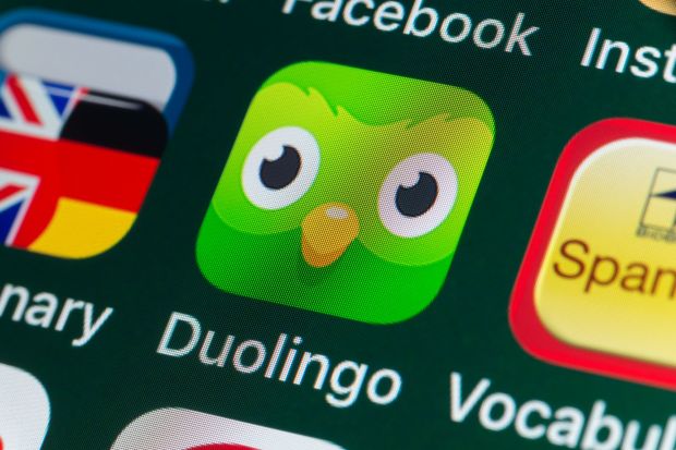 An image collage containing 1 images, Image 1 shows Close-up of the Duolingo app icon on an iPhone screen