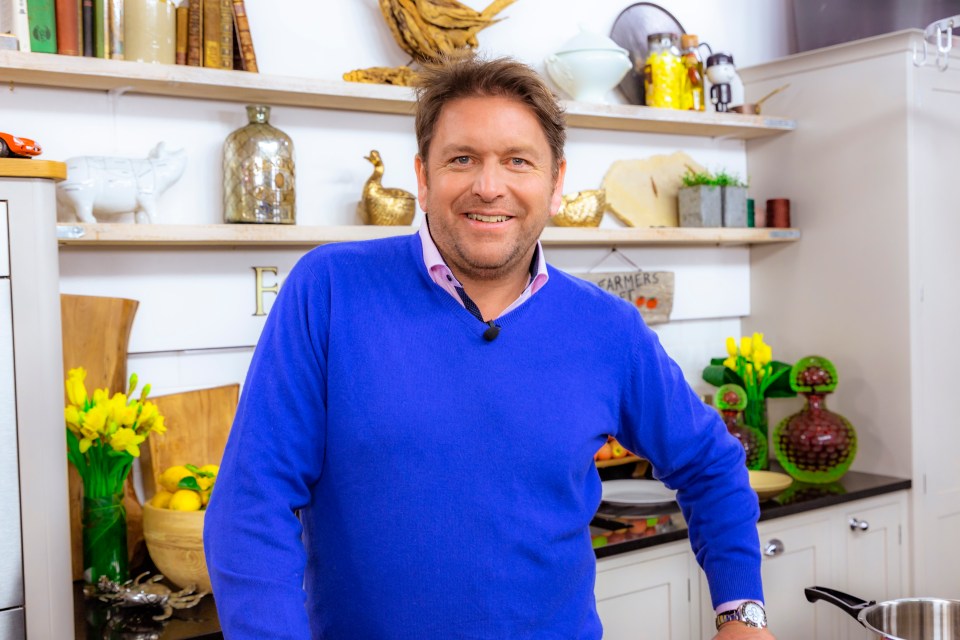 James Martin in a blue sweater in a kitchen.