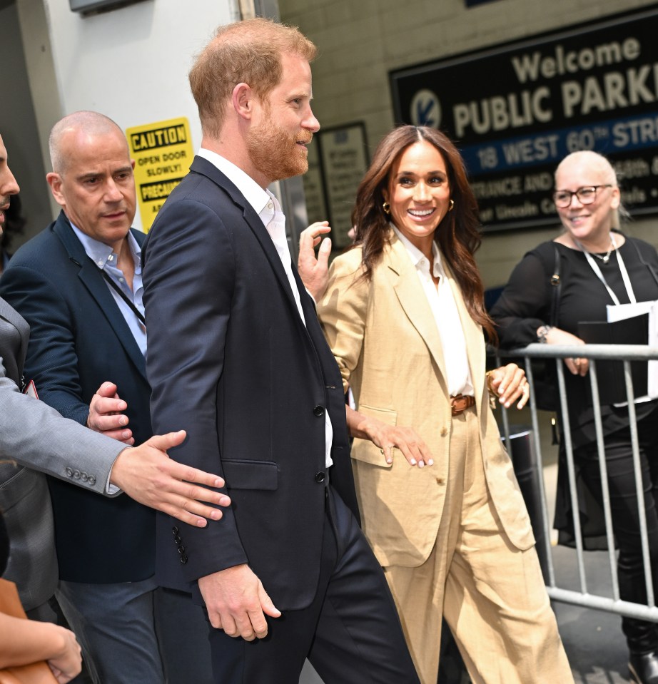 Prince Harry and Meghan Markle leaving a building.