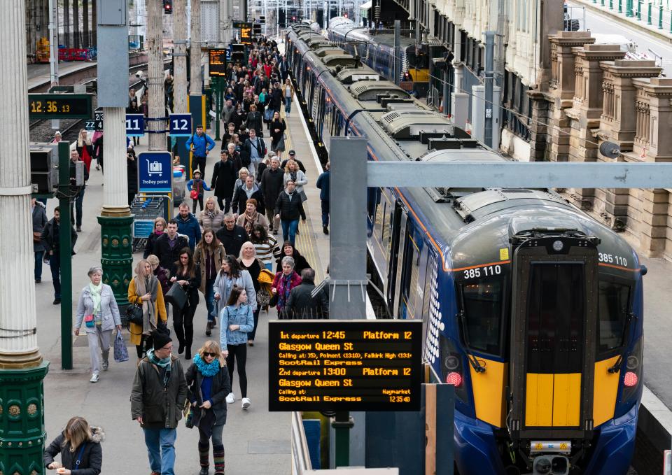 Passengers disembarking a train at a railway station.