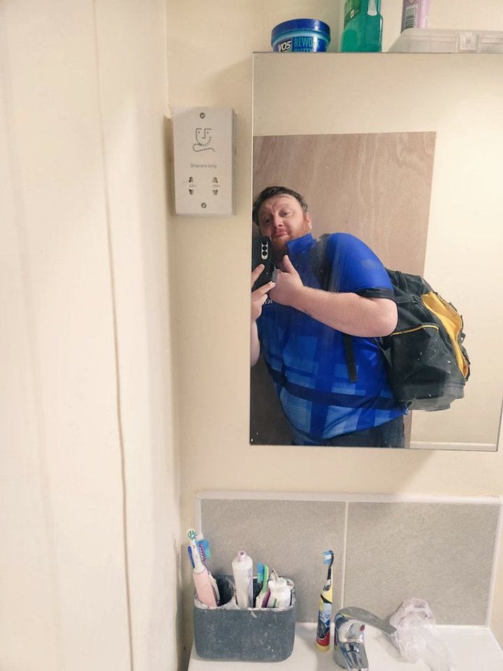 Mirror selfie of a darts player working as a plumber.