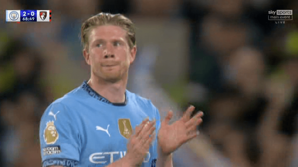 A Manchester City player applauds.