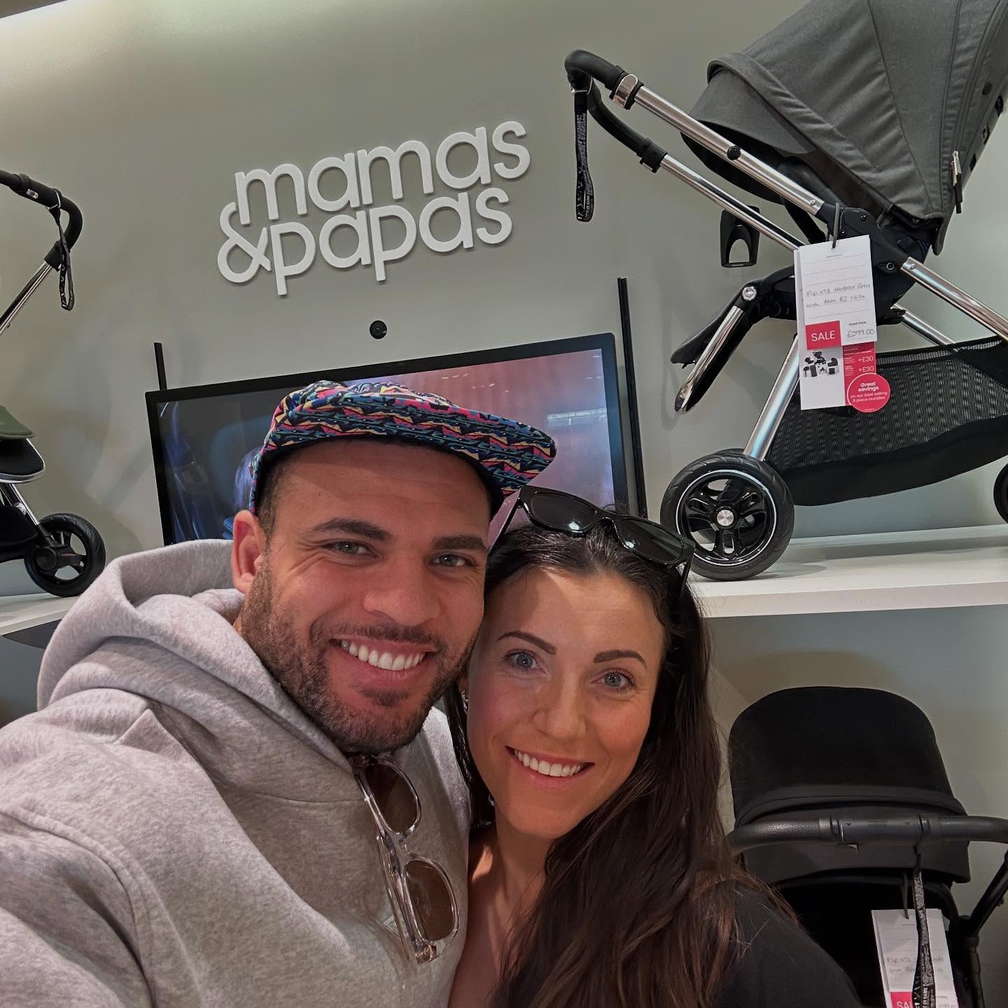 Couple taking a selfie in a Mamas & Papas store.