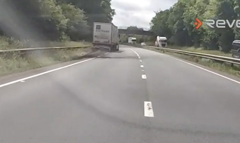 Dashcam footage of a truck swerving on a road.