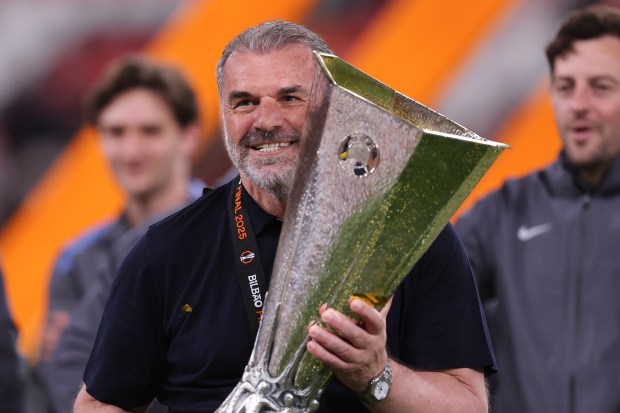 Ange Postecoglou holding the UEFA Europa League trophy.