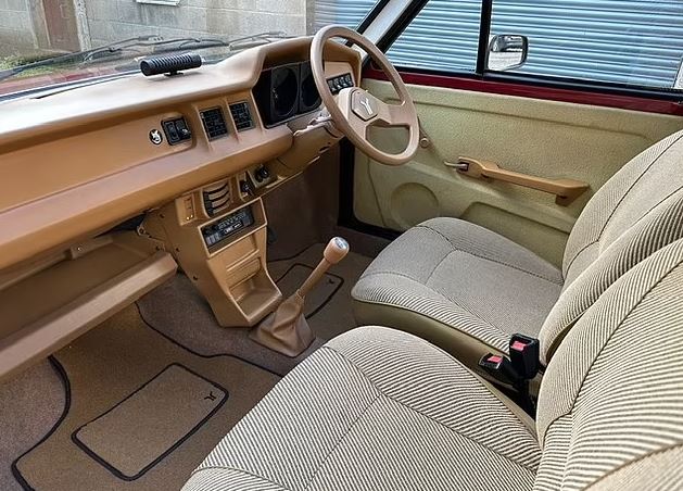 Interior view of a tan and red 1980s car.