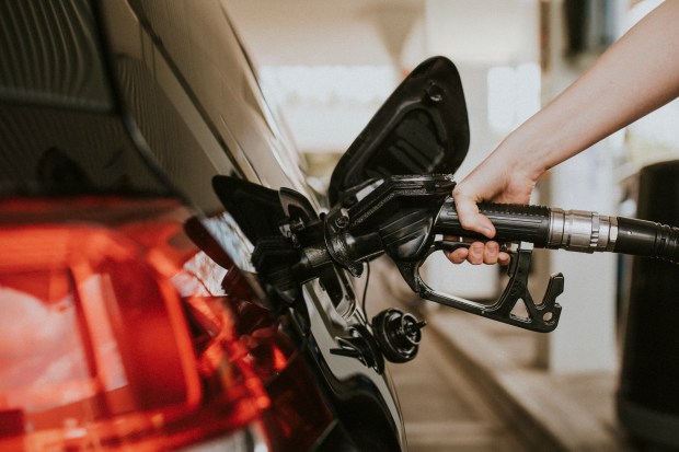 Person pumping gas into a car.